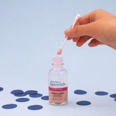 Bye Bye Blemish Drying Lotion Application – Hand dipping a cotton swab into acne drying lotion for targeted spot treatment.