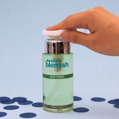 Hand Using Bye Bye Blemish Skin Toner – Hand pressing the dispenser of witch hazel and tea tree toner for skincare application.