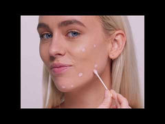 Woman using spot treatment on acne – Acne spot treatment applied with cotton swab for clear skin.